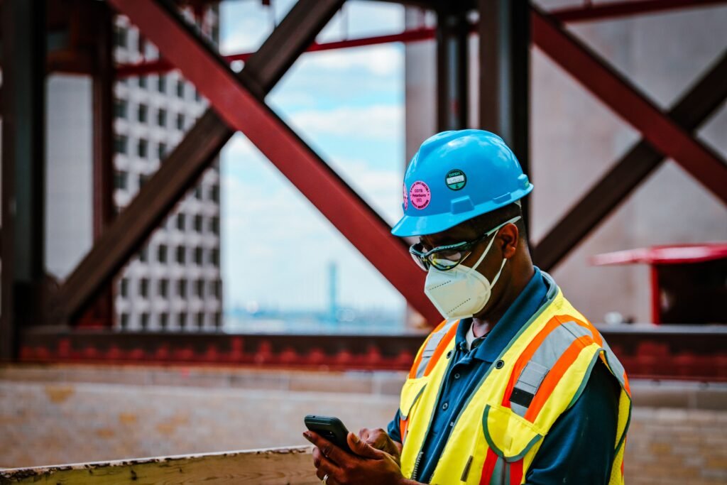 Handwerker mit FFP3-Atemschutzmaske bei staubiger Arbeit auf der Baustelle.