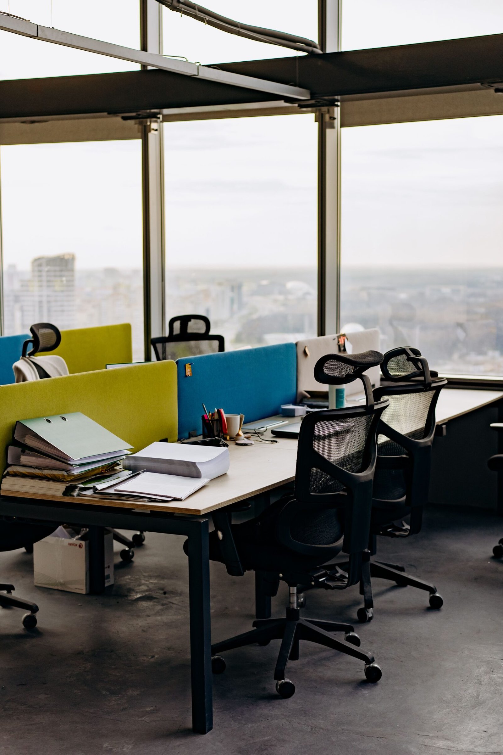 Person sitzt am Arbeitsplatz auf einem Bürostuhl im Büro